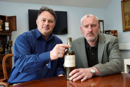 David Robertson and Andy Simpson with the fake bottle of Laphroaig 1903 whisky.
